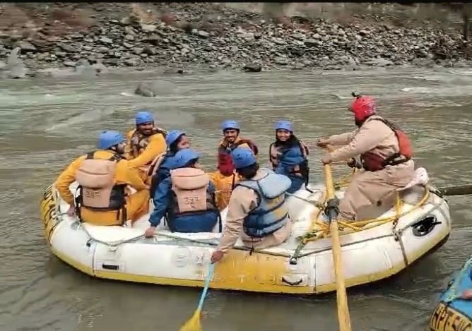 A group of people enjoying river rafting and having fun in the Beas River at Kullu Manali.